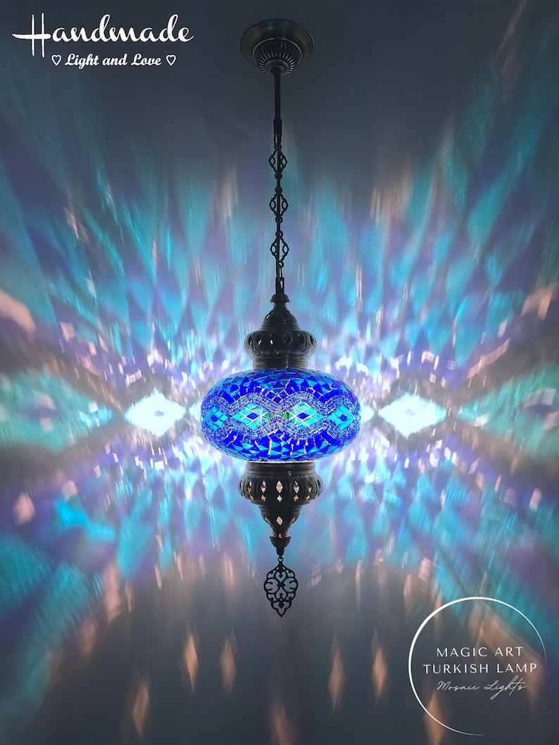 May include: A blue mosaic Turkish lamp with a metal chain hanging from the ceiling. The lamp casts a colorful light pattern on the ceiling. The text "MAGIC ART TURKISH LAMP Mosaic Lights" is visible in the lower right corner of the image.