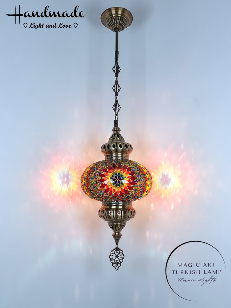 May include: A colorful mosaic Turkish lamp with a brass chain and ornate details. The lamp is lit and casting a warm glow. The text "MAGIC ART TURKISH LAMP Mosaic Lights" is visible below the lamp.