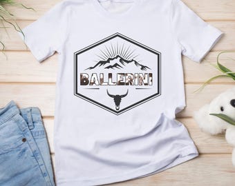 Puede incluir: Camiseta blanca con un diseño gráfico en blanco y negro de una cordillera con el texto "BALLERINI" y una calavera de toro.