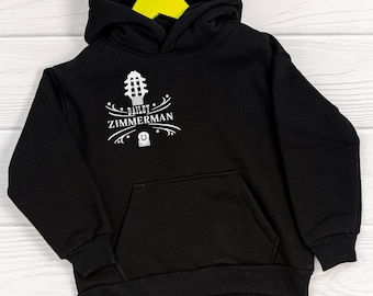 Puede incluir: Sudadera con capucha negra con un gráfico blanco de una guitarra y el texto "BAILEY ZIMMERMAN" en la parte delantera.