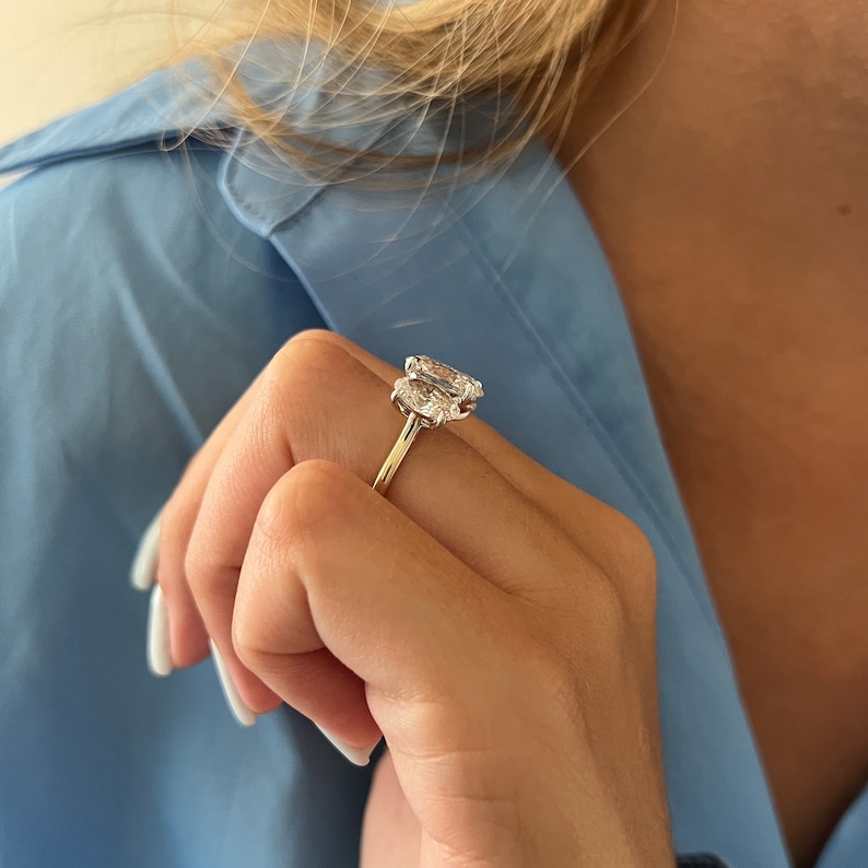 Puede incluir: Un anillo de oro con dos diamantes de forma ovalada engastados en garras.
