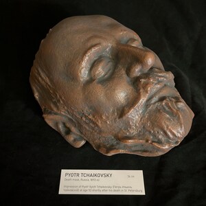Puede incluir: Una m&aacute;scara mortuoria de bronce de Piotr Chaikovski, creada en Rusia en 1893. La m&aacute;scara es una impresi&oacute;n detallada del rostro del compositor, con los ojos cerrados y una barba prominente. La m&aacute;scara mide 26 cm.