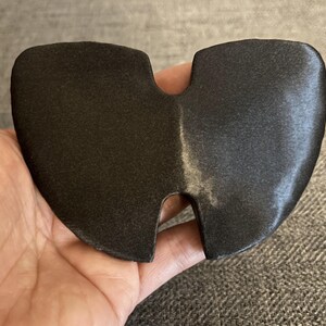 May include: A black, two-piece, foam ear protector with a small opening in the center.