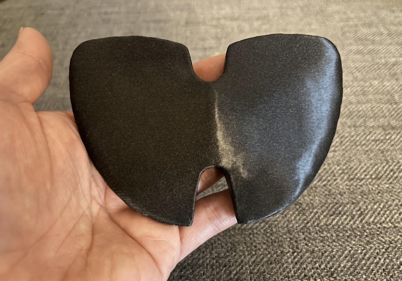 May include: A black, two-piece, foam ear protector with a small opening in the center.