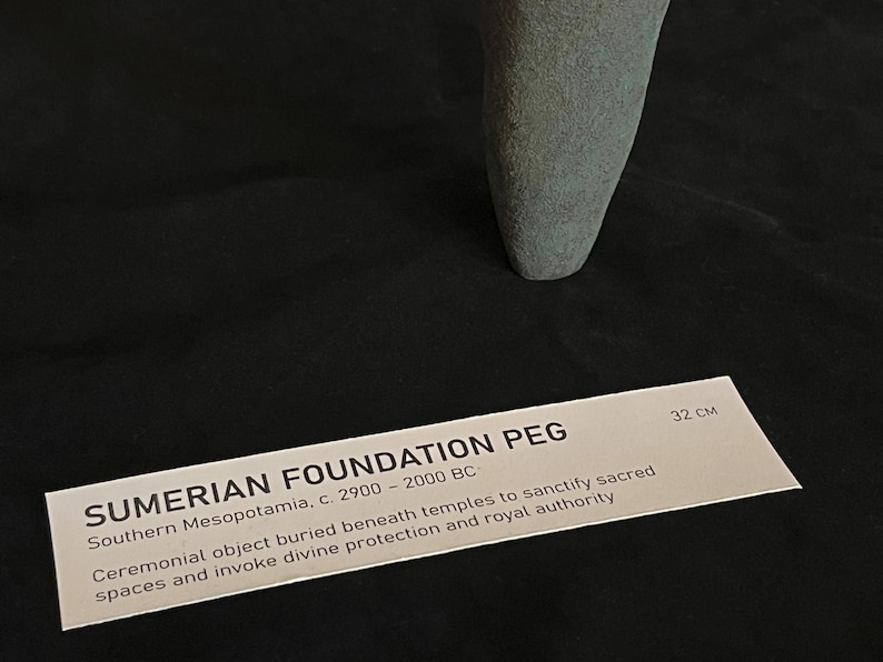 May include: A gray stone Sumerian foundation peg, approximately 32 cm long. It is a ceremonial object buried beneath temples to sanctify sacred spaces and invoke divine protection and royal authority. Southern Mesopotamia, c. 2900-2000 BC.