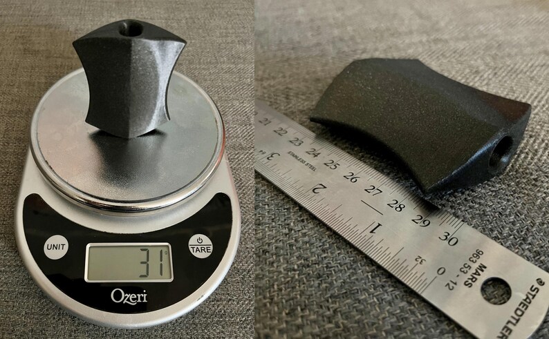 Puede incluir: Una manija de pl&aacute;stico negro con un agujero en el lateral, que pesa 31 gramos. La manija se mide con una regla, mostrando que tiene 7 cm de largo.