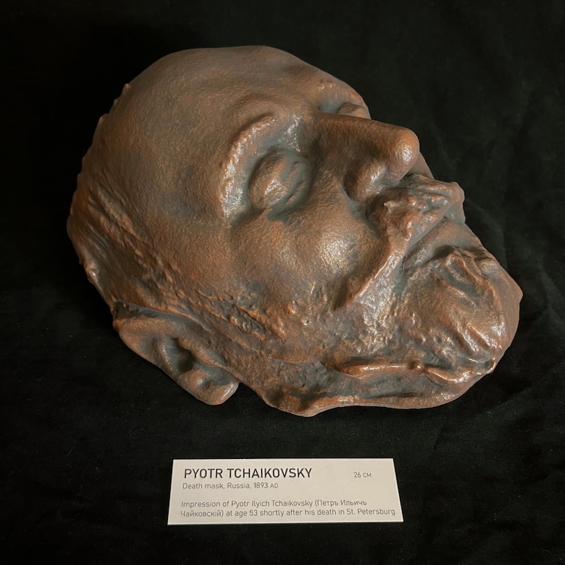 Puede incluir: M&aacute;scara mortuoria de bronce de Pyotr Tchaikovsky, Rusia, 1893. La m&aacute;scara muestra una impresi&oacute;n detallada del rostro del compositor. La etiqueta indica que la m&aacute;scara mide 26 cm de largo. Artefacto hist&oacute;rico.