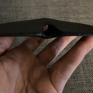 May include: A black ceramic object with a hole in the center, resembling a flying saucer.