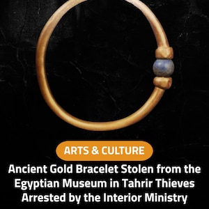 May include: A gold bracelet with a blue bead, set against a black background. The image includes text that reads "ARTS & CULTURE" and "Ancient Gold Bracelet Stolen from the Egyptian Museum in Tahrir Thieves Arrested by the Interior Ministry."