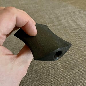 Puede incluir: Una pipa de cer&aacute;mica negra con una abertura redondeada ligeramente acampanada. La pipa tiene una superficie texturizada y un peque&ntilde;o agujero en el lateral.