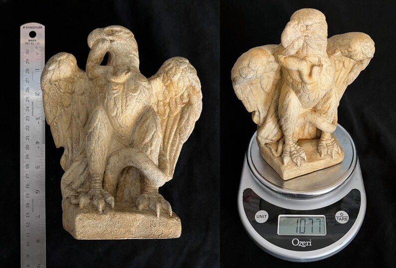 May include: A beige-colored griffin statue with outstretched wings and detailed feather textures. The sculpture is approximately 8 inches tall and is displayed on a digital scale, weighing 1077 grams.