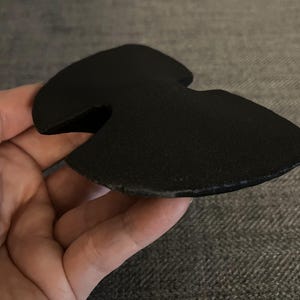 May include: Black foam knee pad with a cut-out shape for the kneecap.
