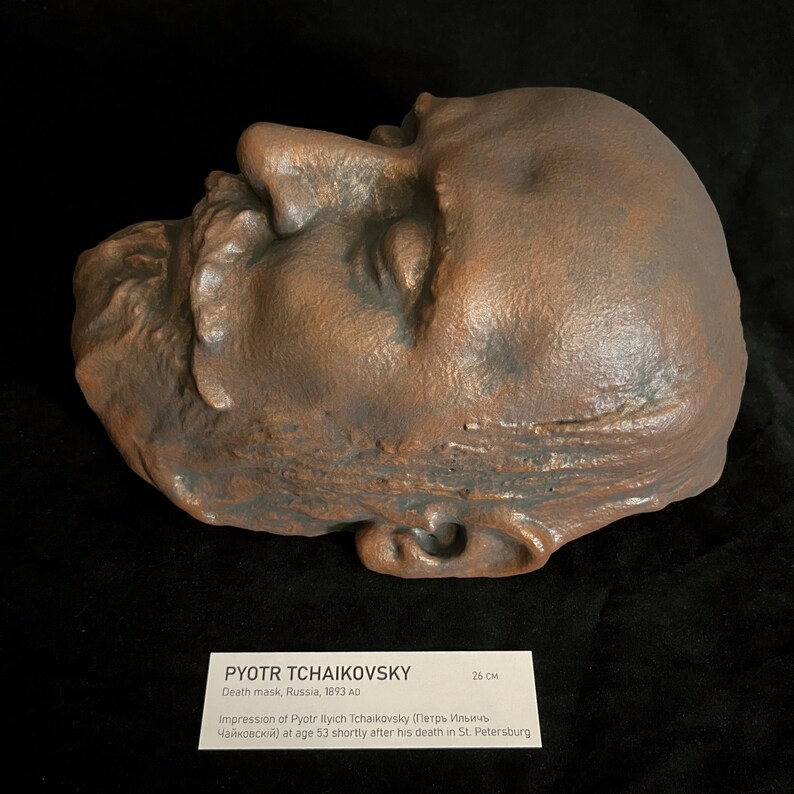 Puede incluir: M&aacute;scara mortuoria de bronce de Piotr Chaikovski, creada en Rusia en 1893. La m&aacute;scara es una impresi&oacute;n detallada del rostro del compositor, con rasgos faciales visibles. La m&aacute;scara mide 26 cm. Una etiqueta proporciona detalles.