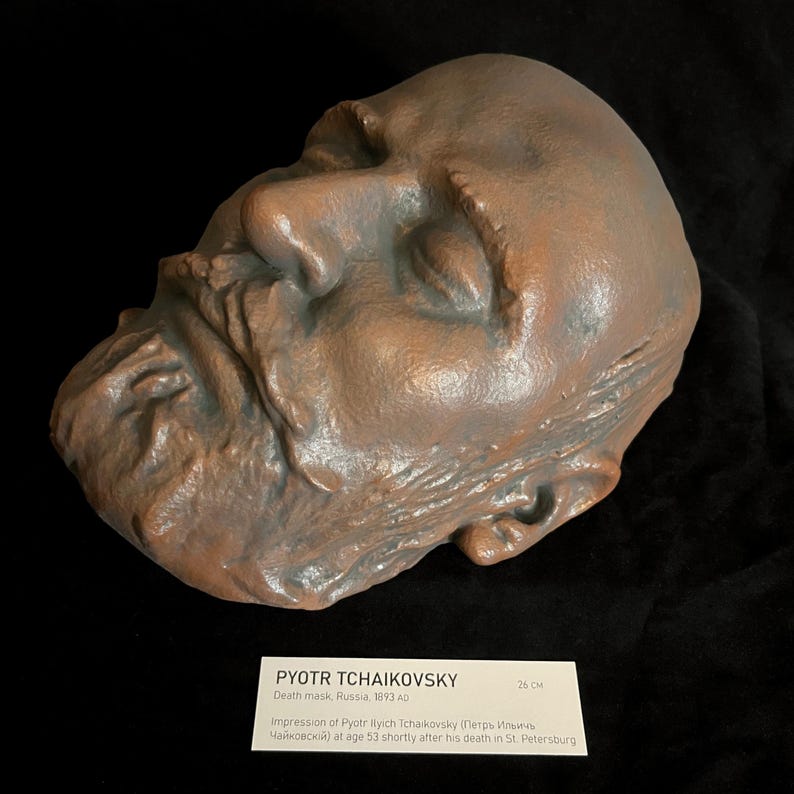 Puede incluir: Una m&aacute;scara mortuoria de color bronce de Pyotr Ilyich Tchaikovsky, creada en Rusia en 1893. La m&aacute;scara es una impresi&oacute;n detallada del rostro del compositor, con rasgos faciales visibles. La m&aacute;scara mide 26 cm.