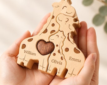May include: A light-coloured wooden puzzle featuring three interlocking giraffe figures with dark brown spots. The names William, Olivia, and Emma are engraved on the base of each giraffe. A dark brown wooden heart is embedded in the largest giraffe.