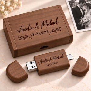 May include: A rectangular wooden box and a matching USB flash drive with dual connectors. Both items are engraved with the text Amelia & Michael and the date 12-2-2023, accompanied by small leaf branch illustrations on the box lid.