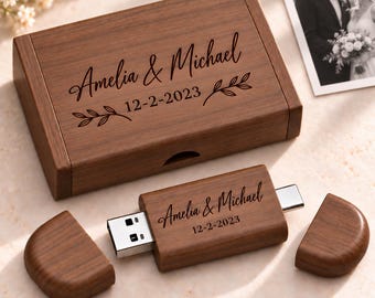 May include: A rectangular wooden box and a matching USB flash drive with dual connectors. Both items are engraved with the text Amelia & Michael and the date 12-2-2023, accompanied by small leaf branch illustrations on the box lid.