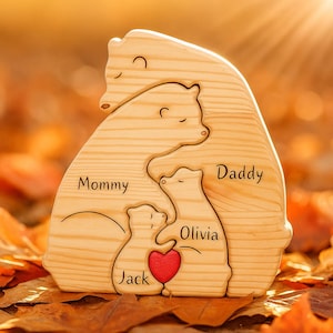 May include: A wooden bear family sculpture with the words "Mommy," "Daddy," "Olivia," and "Jack" carved into the wood. A red heart is carved between the two smaller bears. The sculpture is made of light-colored wood.