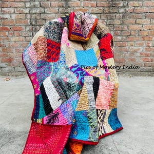 May include: A colorful patchwork quilt with a variety of fabrics and patterns. The quilt features red, blue, pink, and yellow hues, with visible stitching. The text "Pics of Mastery India" is visible on the image.