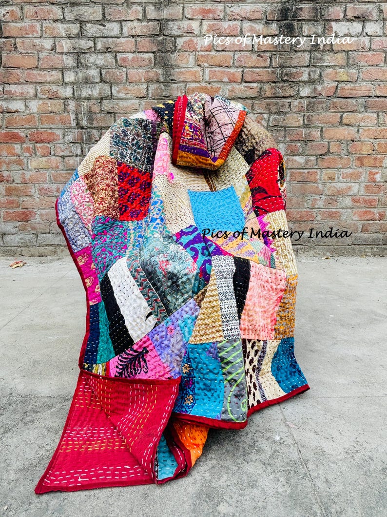 May include: A colorful patchwork quilt with a variety of fabrics and patterns. The quilt features red, blue, pink, and yellow hues, with visible stitching. The text "Pics of Mastery India" is visible on the image.
