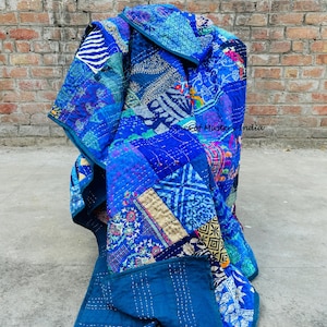 Puede incluir: Un edredón patchwork azul vibrante con varios patrones y texturas. El edredón presenta una mezcla de diseños florales, geométricos y abstractos en tonos de azul, turquesa e índigo. El texto "Pics of Mastery India" es visible.