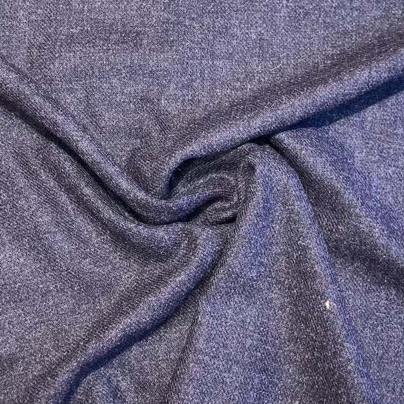 Puede incluir: Primer plano de una tela azul oscuro con un brillo sutil. La tela tiene una textura casi de punto.
