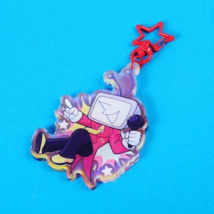 Peut inclure: Un porte-clés en acrylique transparent représentant un personnage de dessin animé avec une tête d'écran de télévision, vêtu d'un costume rose et tenant un microphone. Le porte-clés a un fermoir rouge en forme d'étoile et un fond holographique, sur fond bleu.