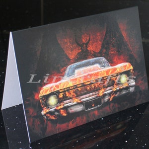 May include: A fiery orange and red muscle car with flames painted on the hood and sides. The car is set against a dark background with a shadowy figure with wings in the background.
