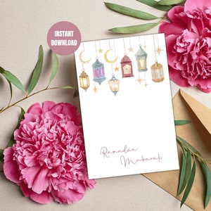 May include: Printable card with a watercolor illustration of lanterns and stars hanging from a string. The card has the text "Ramadan Mubarak" in a cursive font.