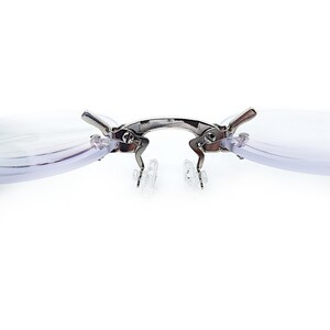 May include: A pair of silver-toned clip-on reading glasses with clear lenses. The glasses have a spring-loaded hinge and are designed to attach to existing eyeglasses.