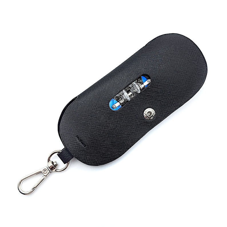 May include: A black leather key chain with a silver clasp and a small black leather pouch with a blue and silver multi-tool inside.