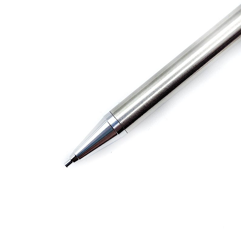 May include: A sleek mechanical pencil with a brushed silver metal barrel and a polished silver conical tip. The writing instrument features a slender, cylindrical design that tapers toward the point, showcasing a clean and metallic aesthetic.
