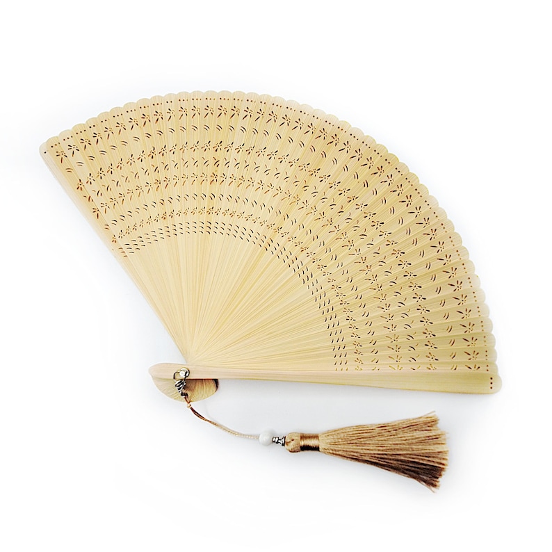 May include: A light brown bamboo hand fan with a delicate floral pattern and a brown tassel.