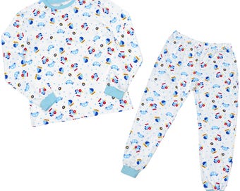 May include: A white long-sleeve pajama set for babies with a blue and red print of cars, airplanes, and crowns. The set includes a top and pants. The text "Diaper'U" and "abdl metaverse" is at the bottom of the image. The text "Long-Sleeve Pajama Set Baby Adventure" is at the bottom of the image.
