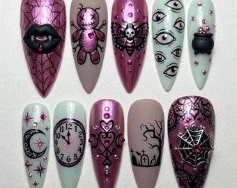 Könnte beinhalten: Ein Set aus zehn mandelförmigen Press-on-Nägeln mit verschiedenen Motiven, darunter ein Vampirmund, eine Voodoo-Puppe, ein Nachtfalter, Augen, ein Kessel, ein Mond, eine Uhr, verzierte Herzen, ein Friedhof und ein Spinnennetz-Anhänger.