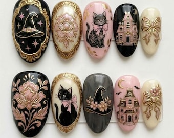 Könnte beinhalten: Ein Set aus zehn künstlichen Fingernägeln mit detaillierten Motiven in Schwarz, Rosa, Creme und Gold. Die Designs zeigen einen Hexenhut, florale Muster, eine schwarze Katze mit rosa Schleife, ein Spukhaus und eine dekorative Schleife in Relief.