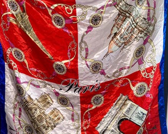 Könnte beinhalten: Ein quadratisches Tuch mit einem in vier Quadranten unterteilten Design in Rot und Weiß mit blauem Rand. Der Druck zeigt Illustrationen des Eiffelturms, von Notre-Dame und des Arc de Triomphe, akzentuiert durch goldene Ketten und das Wort Paris.