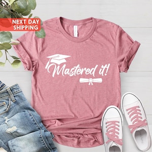 May include: A pink t-shirt with the text "Mastered it!" in white. A graduation cap and diploma are above and below the text.