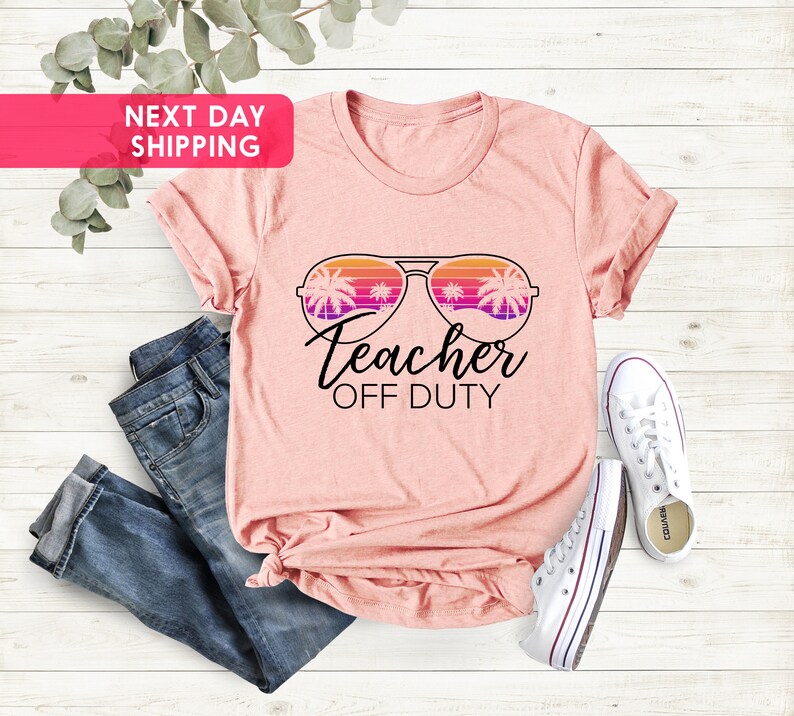 May include: Pink t-shirt with a graphic of sunglasses with palm trees reflected in the lenses. The text "Teacher Off Duty" is below the sunglasses.