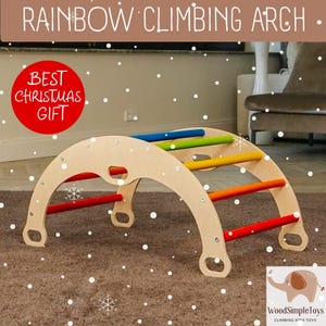 Può includere: Un arco rampicante arcobaleno in legno con pioli colorati. L'arco è realizzato in legno chiaro e ha pioli rossi, arancioni, gialli, verdi e blu. Il testo "RAINBOW CLIMBING ARCH" è in alto. Un cerchio rosso dice "BEST CHRISTMAS GIFT".