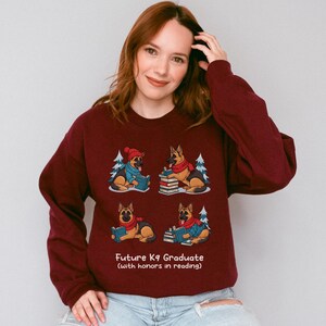 Future K9 Graduate Sweatshirt. This cozy German Shepherd shirt features four cute German Shepherds reading books, making it a perfect dog lover gift. It's an ideal bookish jumper and a great Xmas gift for dog moms and dog dads who love reading. This holiday sweatshirt is a funny and charming way to celebrate a love for dogs and books during the winter holiday season.