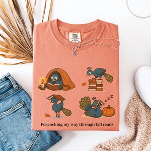 Comfort Colors shirt with whimsical peacock illustrations reading books, paired with pumpkins and cozy fall designs, perfect book lover tee.
Book Lover Comfort Colors Tee.nautumn gift for bookworms, librarians, teachers, and peacock lovers.
peacock shirt, funny peacock tee, peacock lover gift, book lover shirt, fall reading shirt, comfort colors tee, bookish shirt, librarian gift, cute peacock shirt, autumn book shirt, teacher gift tee, book club shirt, cozy fall shirt