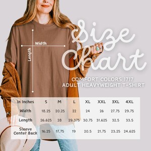 May include: A size chart for a Comfort Colors 1717 adult heavyweight t-shirt. The chart shows measurements in inches for width, length, and sleeve center back for sizes S through 4XL. The shirt is a solid brown color.