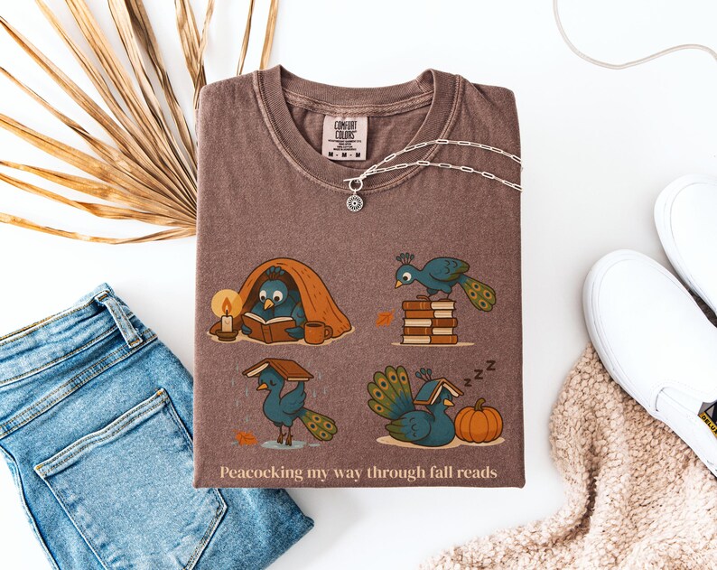 Comfort Colors shirt with whimsical peacock illustrations reading books, paired with pumpkins and cozy fall designs, perfect book lover tee.
Book Lover Comfort Colors Tee.nautumn gift for bookworms, librarians, teachers, and peacock lovers.
peacock shirt, funny peacock tee, peacock lover gift, book lover shirt, fall reading shirt, comfort colors tee, bookish shirt, librarian gift, cute peacock shirt, autumn book shirt, teacher gift tee, book club shirt, cozy fall shirt