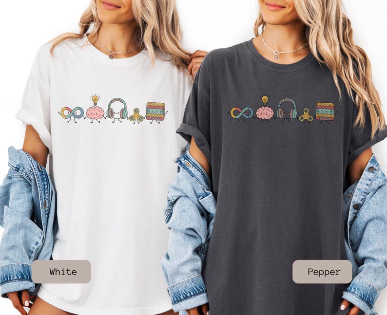 Comfort Colors Autism Doodle Characters Shirt featuring colorful, hand-drawn inclusive characters. Neatly styled next to classroom supplies, making it an ideal inclusion shirt, autism teacher shirt, and back to school shirt.