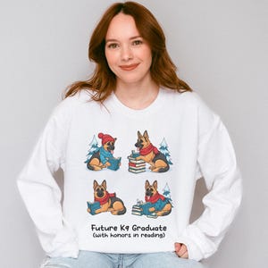 Future K9 Graduate Sweatshirt. This cozy German Shepherd shirt features four cute German Shepherds reading books, making it a perfect dog lover gift. It's an ideal bookish jumper and a great Xmas gift for dog moms and dog dads who love reading. This holiday sweatshirt is a funny and charming way to celebrate a love for dogs and books during the winter holiday season.