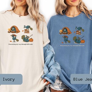 Comfort Colors shirt with whimsical peacock illustrations reading books, paired with pumpkins and cozy fall designs, perfect book lover tee.
Book Lover Comfort Colors Tee.nautumn gift for bookworms, librarians, teachers, and peacock lovers.
peacock shirt, funny peacock tee, peacock lover gift, book lover shirt, fall reading shirt, comfort colors tee, bookish shirt, librarian gift, cute peacock shirt, autumn book shirt, teacher gift tee, book club shirt, cozy fall shirt