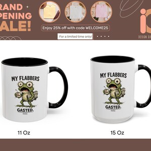 K&ouml;nnte beinhalten: Zwei wei&szlig;e Keramikbecher mit schwarzem Innenraum und Griffen. Jeder Becher zeigt einen Cartoon-Frosch mit dem Text "MY FLABBERS GASTED." Die Becher sind mit 11 oz und 15 oz beschriftet. Das Bild enth&auml;lt auch Werbetext.