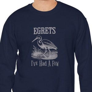 May include: Navy blue sweatshirt with a white egret illustration and the text "Egrets I've Had A Few".