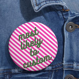 May include: A circular pinback button featuring a vibrant pattern of diagonal hot pink and white stripes. The text "most likely to custom" is printed across the centre in a dark green, cursive-style font, creating a bold and clear visual contrast.